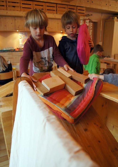 Kinder weben gemeinsam an einem grossen Webrahmen