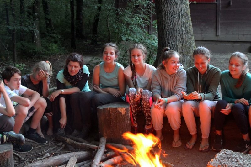 Jugendliche sitzen abends am Lagerfeuer