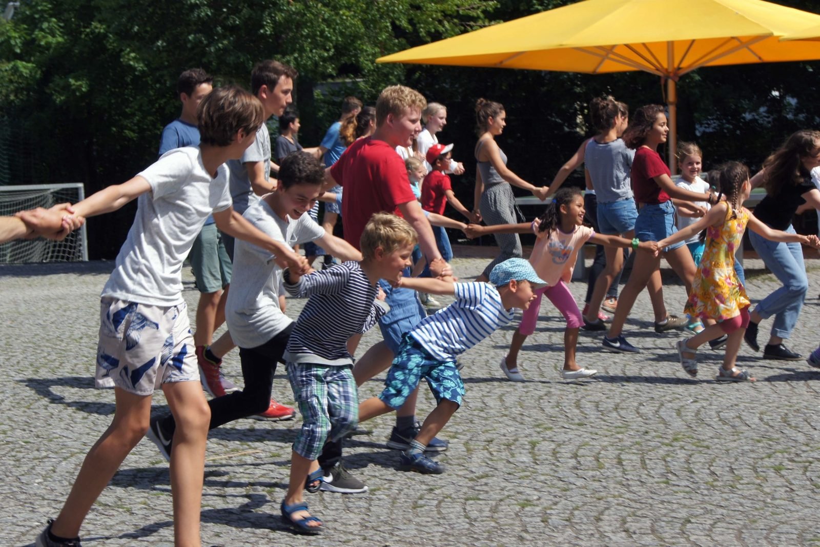 Ältere und jüngere Kinder spielen zusammen in der Pause