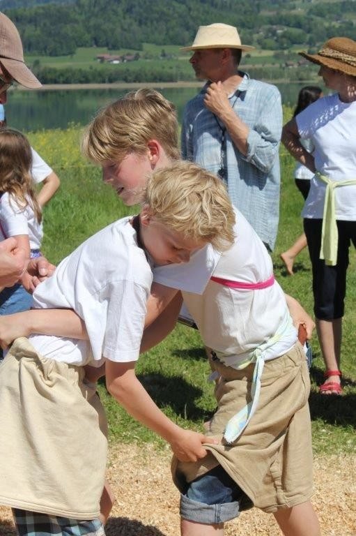 Kinder arbeiten an einem Sommertag draussen mit der Säge