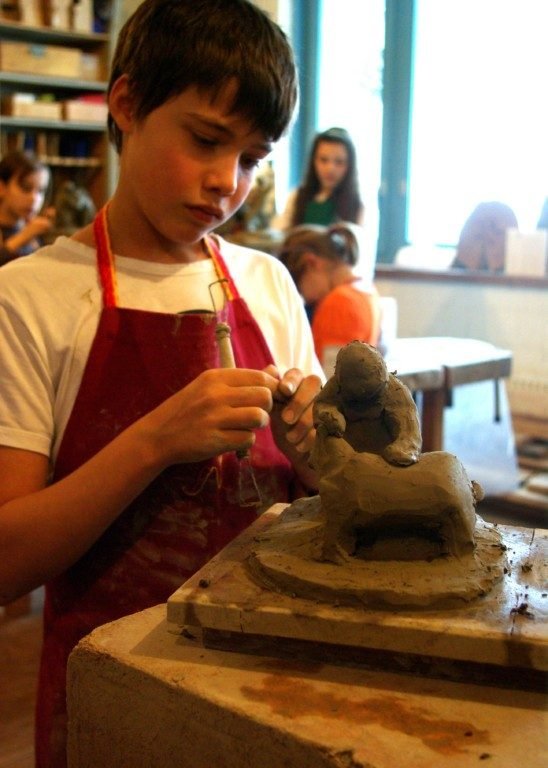 Ein Kind formt eine Figur aus Ton