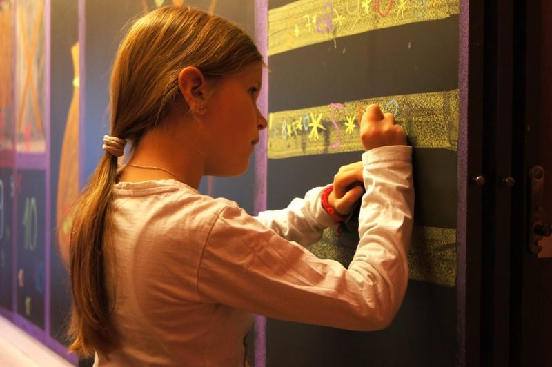 Ein Kind schreibt an der Wandtafel im Hauptunterricht